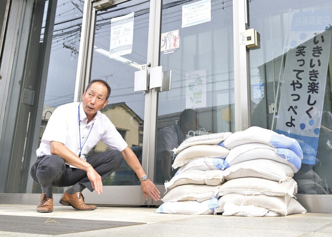 台風接近に備え、地域福祉交流センターの正面玄関に土のうを用意する金沢節さん=北茨城市磯原町本町、鈴木葵撮影
