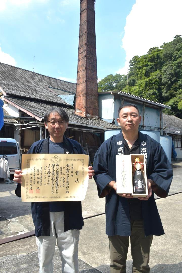 金賞受賞酒「大吟醸　白菊」を手にする廣瀬商店八代目の廣瀬慶之助さん(右)と杜氏の久保田通生さん=石岡市高浜
