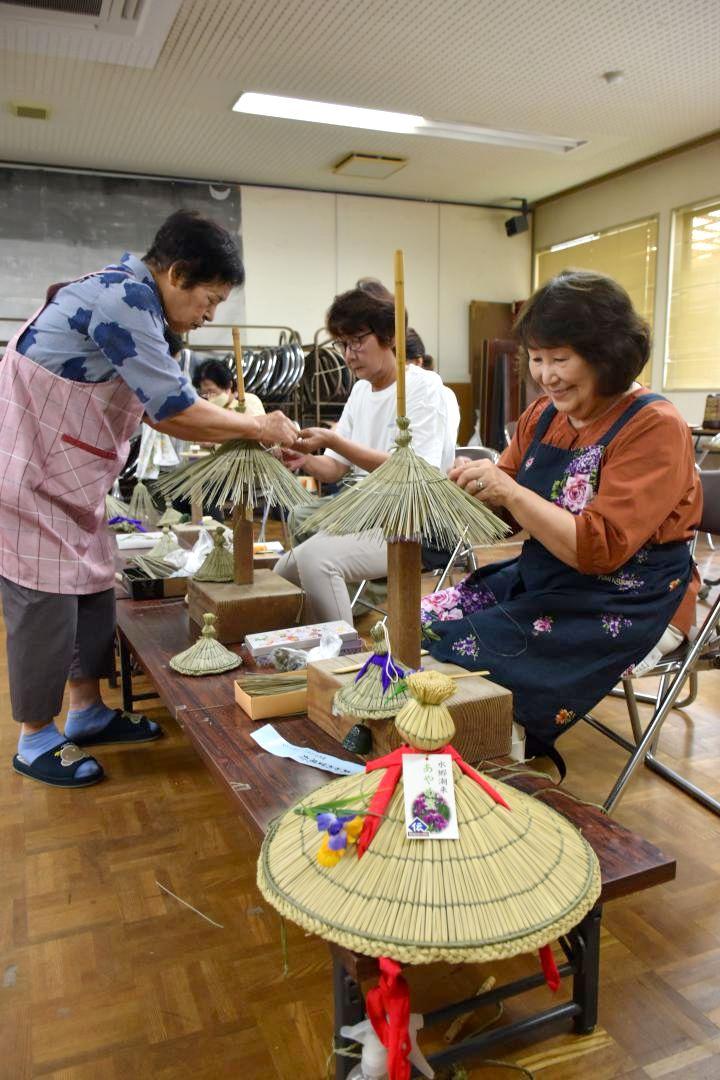 高橋トシ子さん(左)らのアドバイスを受けながら風鈴笠を製作する参加者=潮来市辻
