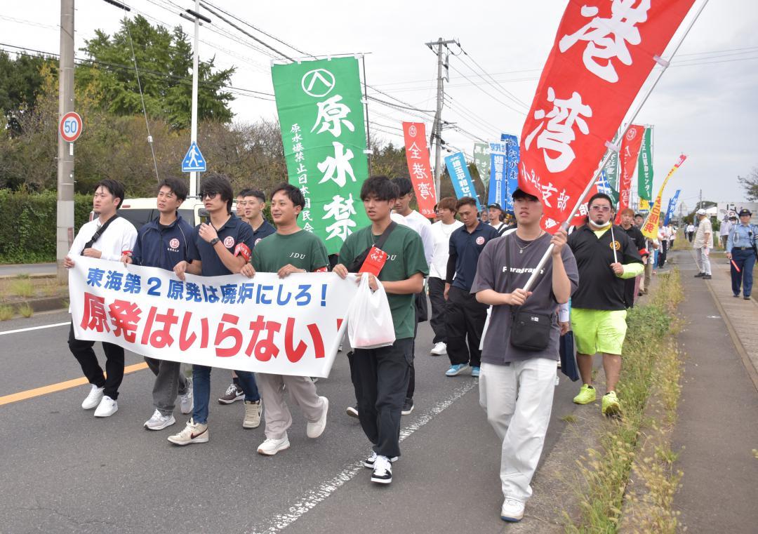 臨界事故の風化防止や原発の再稼働反対を訴えてデモ行進する参加者=東海村石神内宿
