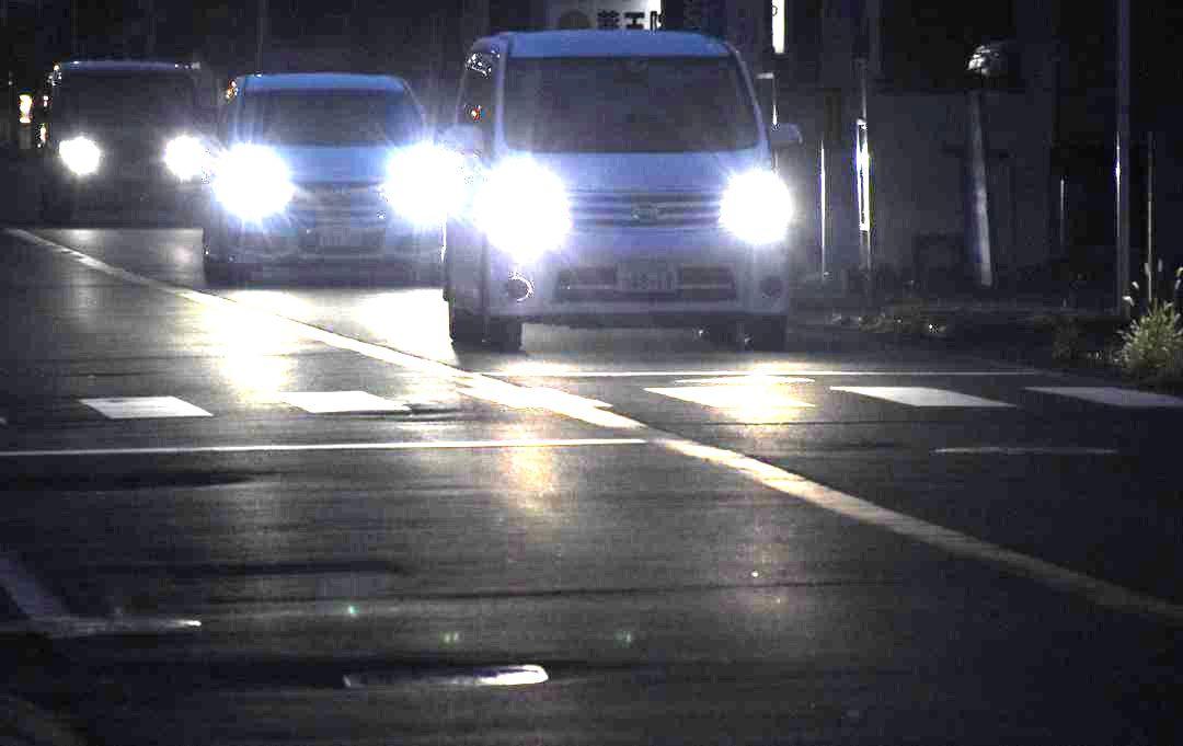 夜間に前照灯をつけて走行する車=水戸市内
