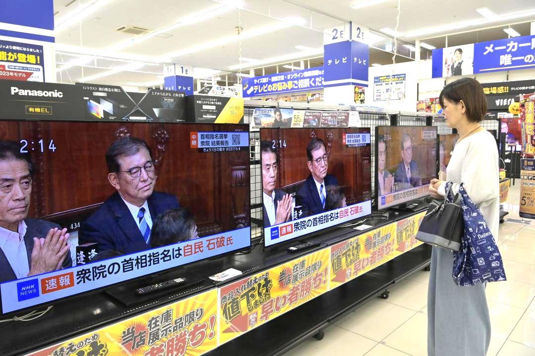 家電量販店で新首相選出を伝えるテレビを見る来店客=1日午後2時14分、土浦市上高津のノジマイオン土浦店
