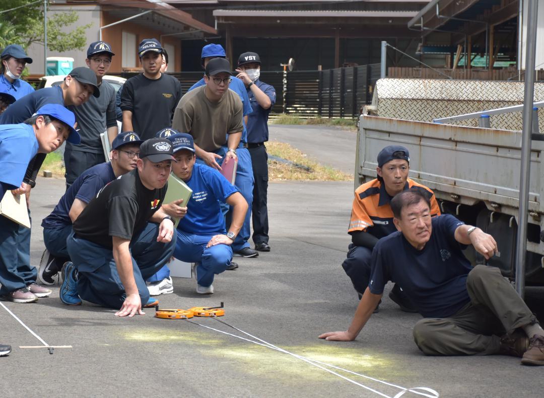 衝突実験で路面に残った車のブレーキ痕や衝突した場所を確認する警察官ら=牛久市猪子町
