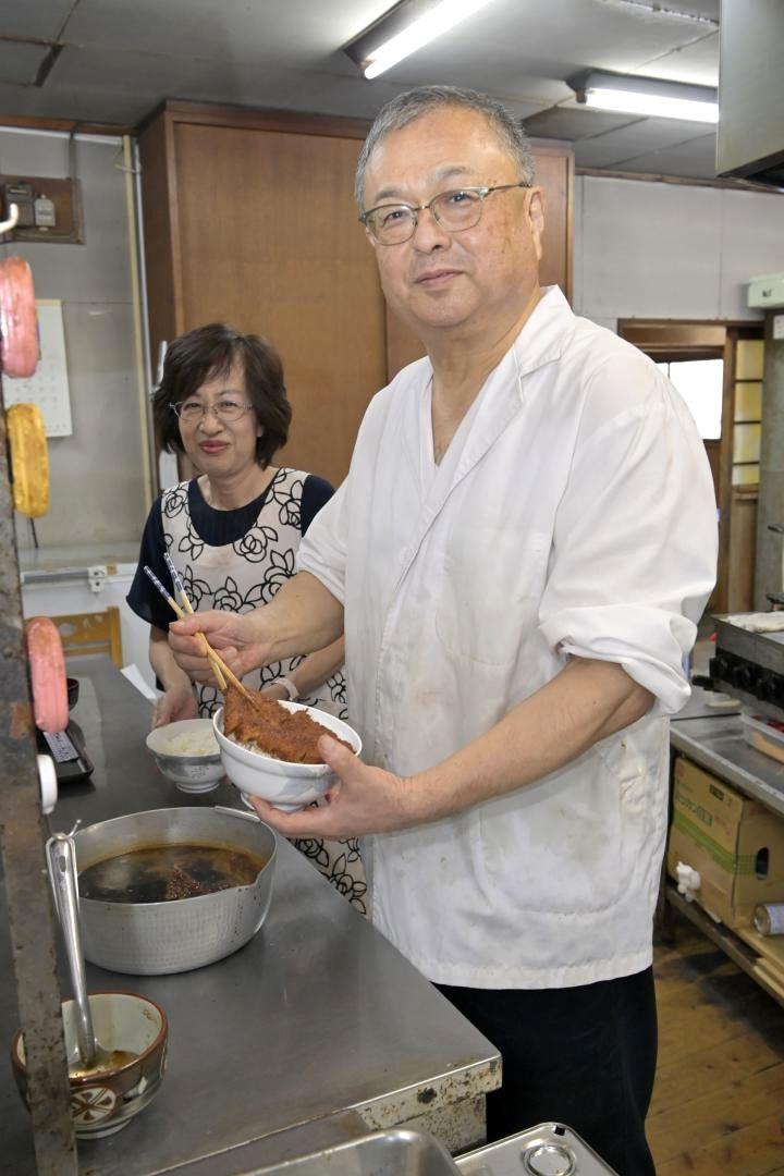 ソースカツ丼を盛り付ける店主の塩原政靖さん(右)と妻の幸子さん=常陸太田市西三町
