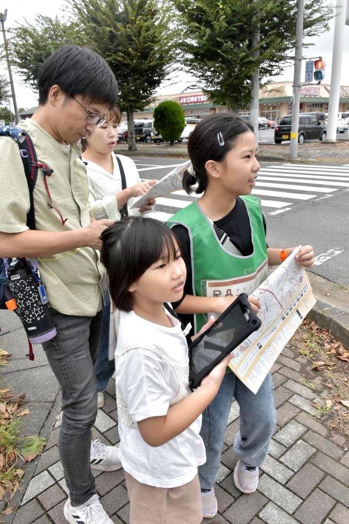 ナビゲーションスポーツ「ロゲイニング」を楽しむ親子。地図に記された地域の史跡や飲食店を巡る=つくば市筑穂
