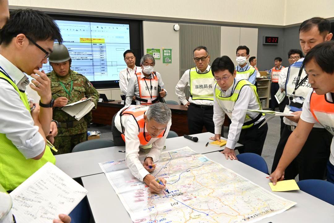 原子力災害を想定した図上訓練で避難経路となる道路の復旧などを地図上に記して対応の調整を図る県と関係機関=県庁
