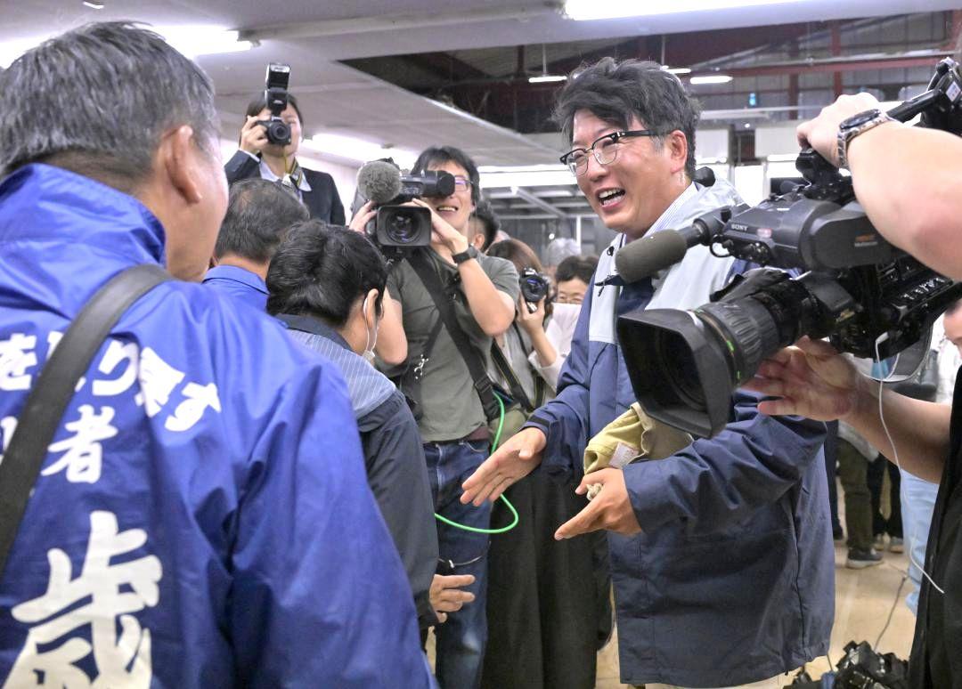 小選挙区で初当選が確実となり、支持者と握手を交わす中村勇太氏=27日午後10時50分、古河市下辺見
