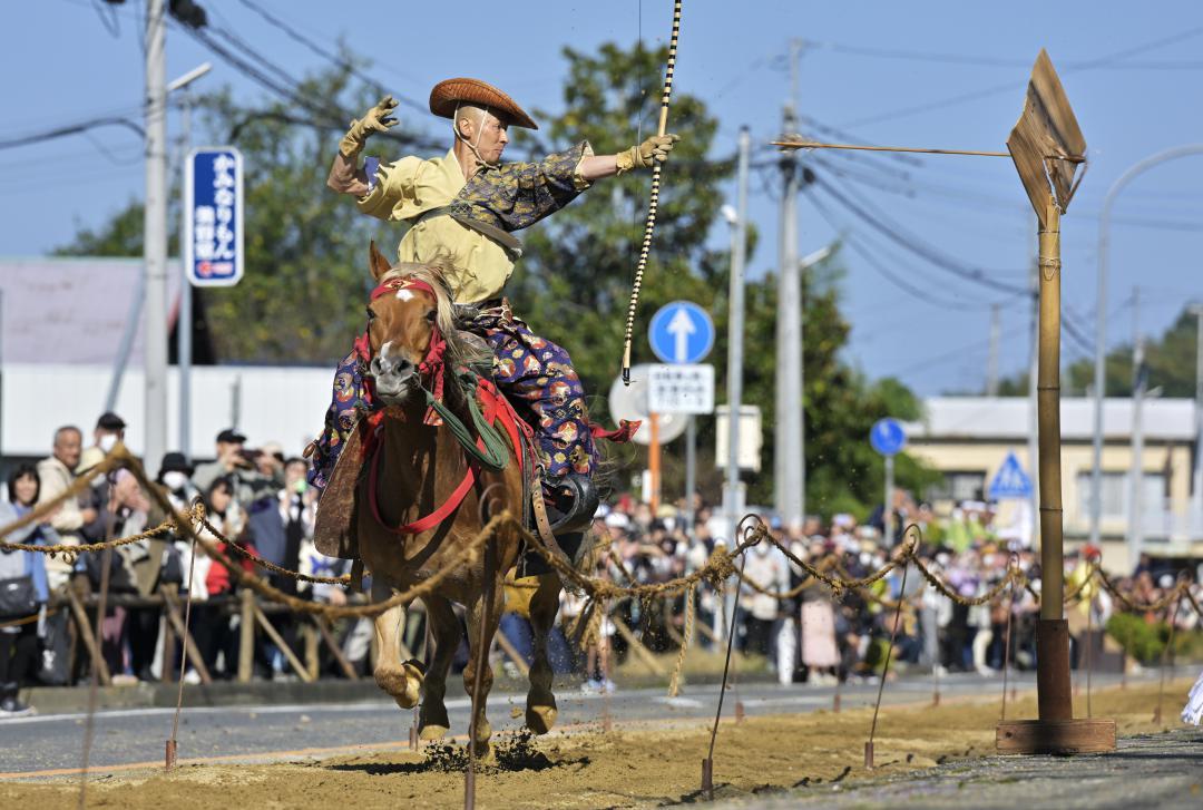 疾走する馬上から矢を放ち、的に命中させる射手=3日午前、笠間市笠間