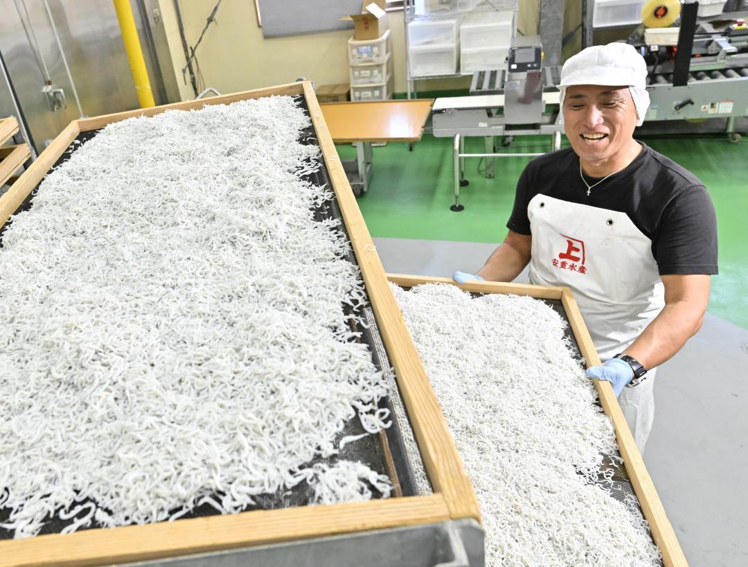 ゆでたてのシラスがたっぷり乗ったせいろを手に笑顔を見せる「安重水産」の安重幸次さん=鹿嶋市武井釜
