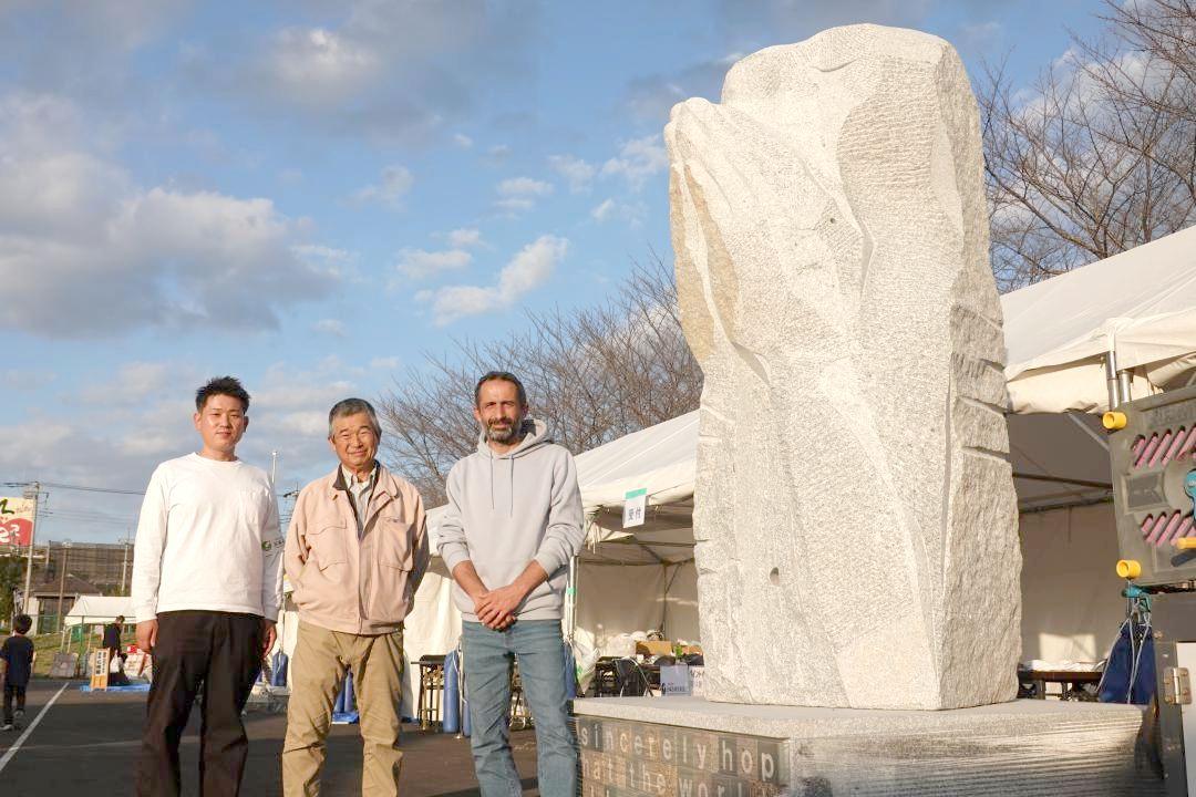 「平和への祈り」の石像を制作したイヴァン・ストヤノフさんと、浅賀正治さん、石産協加工部会長の北島敏行さん(右から)=笠間市赤坂
