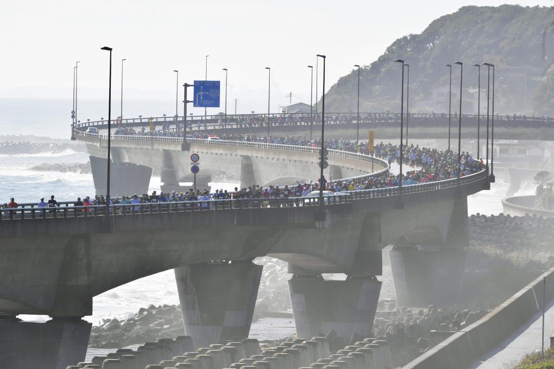 潮風を受けながら国道6号日立バイパスを走る選手たち=日立市旭町
