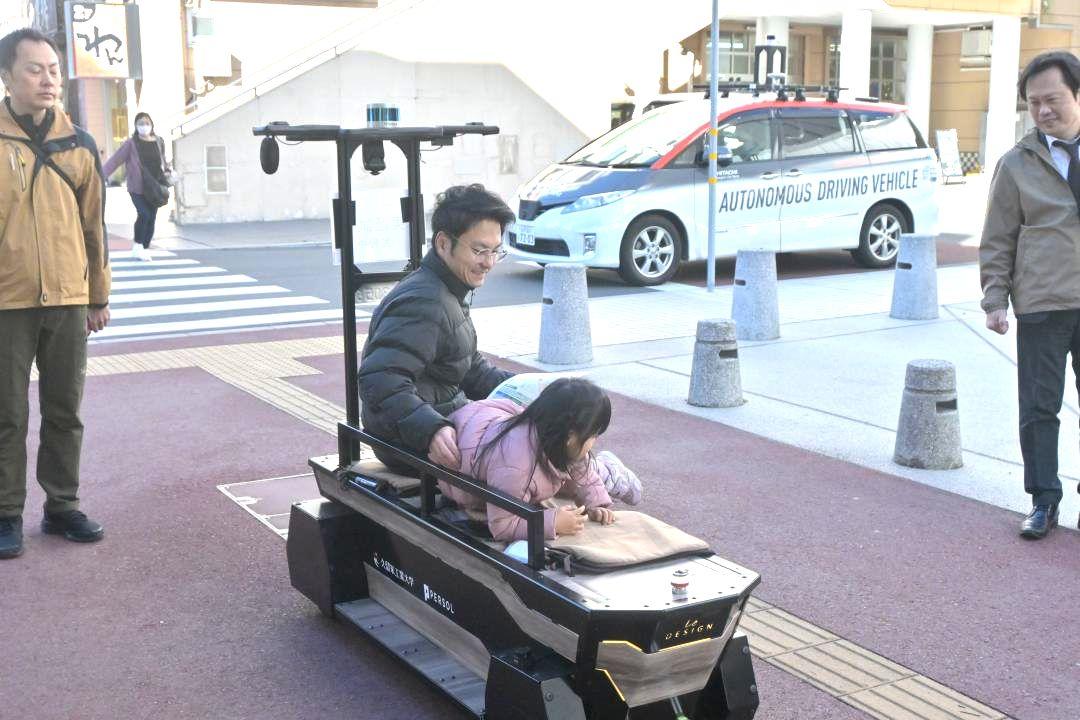 乗車体験できるベンチ型モビリティー(手前)と自動運転車(奥)=日立市幸町
