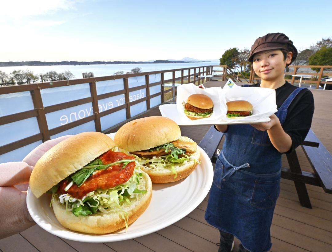 霞ケ浦を一望するテラス席で、「なめパックン」(左端)や「鯉パックン」(左から2個目)などの行方バーガーを楽しむことができる=行方市玉造甲
