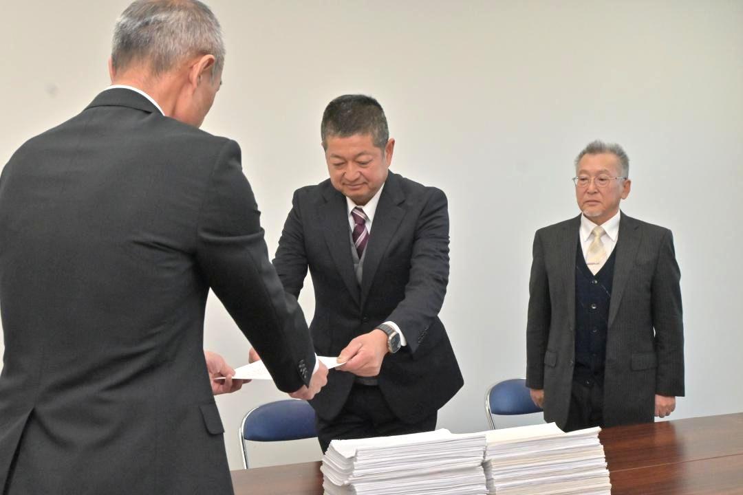 請求書を提出する鴨志田征央さん(中央)と三代喜良さん=日立市役所
