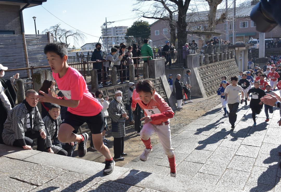 羽黒神社の階段を駆け上がる「招福舘男舘女」の参加者ら=筑西市甲
