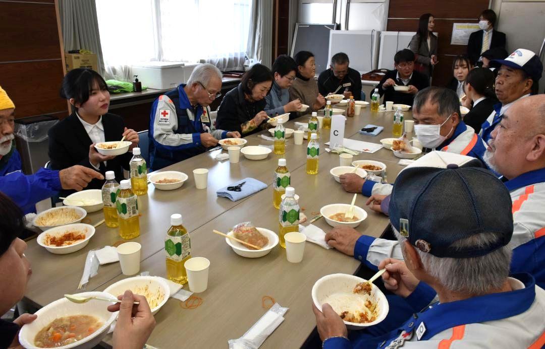 トマトカレーとお麩じゃがを味わう常磐大生や赤十字奉仕団員ら=水戸市小吹町
