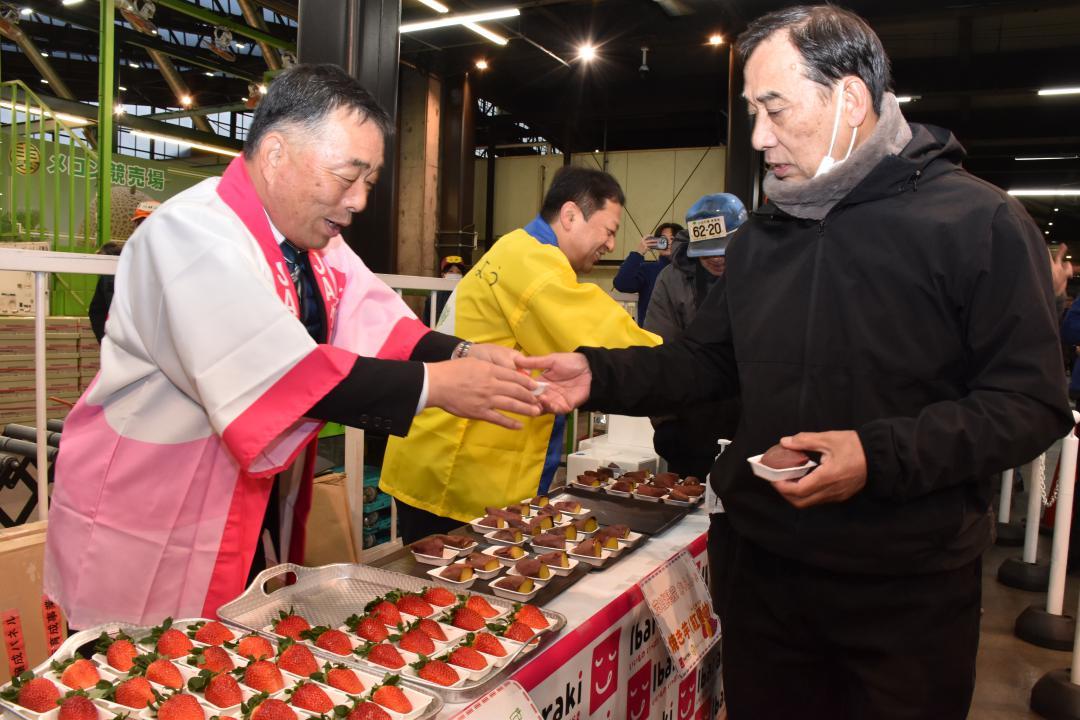 県産品の試食を手渡す八木岡努全農県本部運営委員会長(左手前)と岩下泰善副知事=東京都大田区
