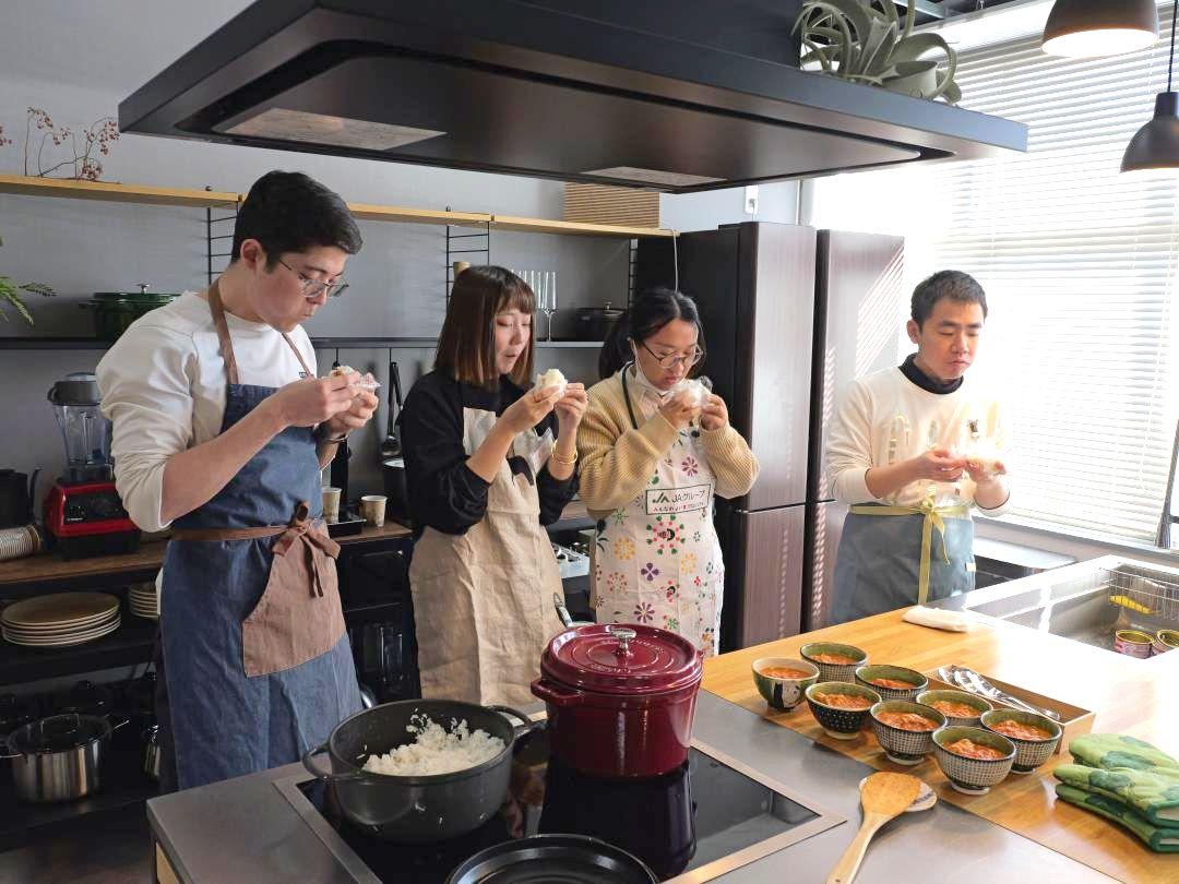 自分たちで作ったおにぎりを食べる留学生たち=水戸市梅香
