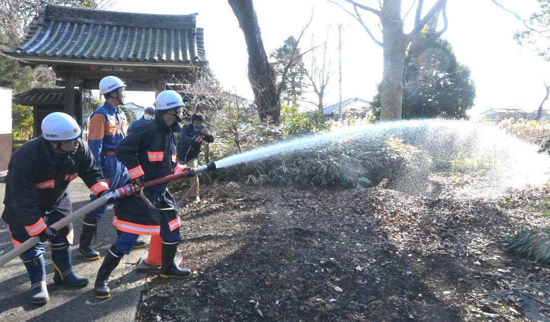 願入寺で防火訓練する町消防署員ら。奥は町指定文化財の山門=大洗町磯浜町
