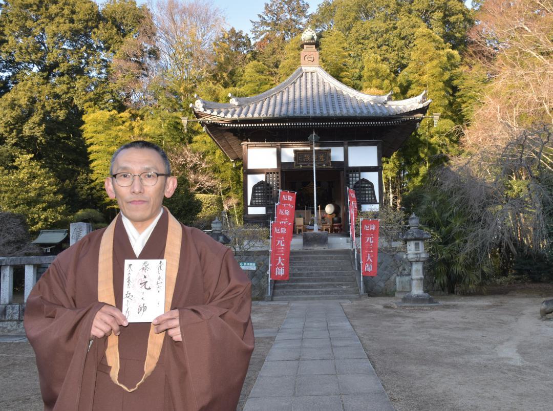 御朱印を手に安樂寺について説明する松永博臣住職=常総市大輪町
