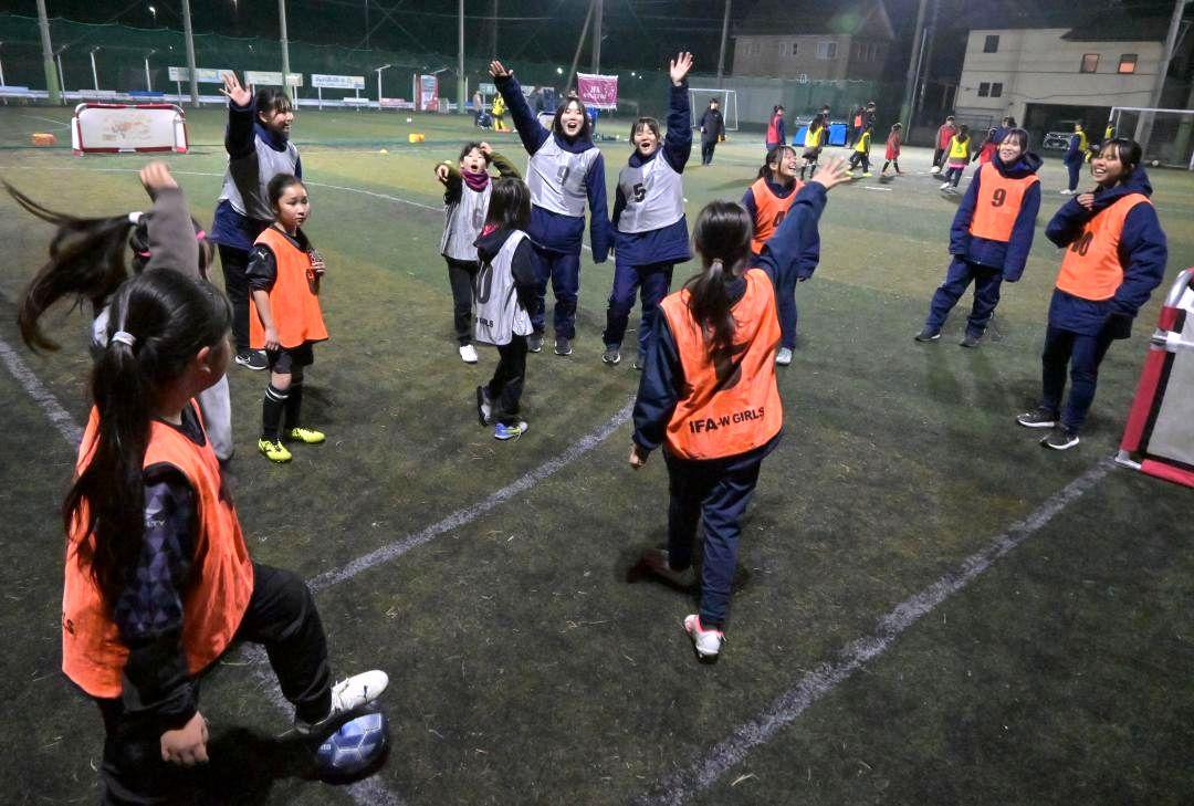 女子限定のスクールで高校生と一緒にサッカーを楽しむ小学生たち=日立市茂宮町
