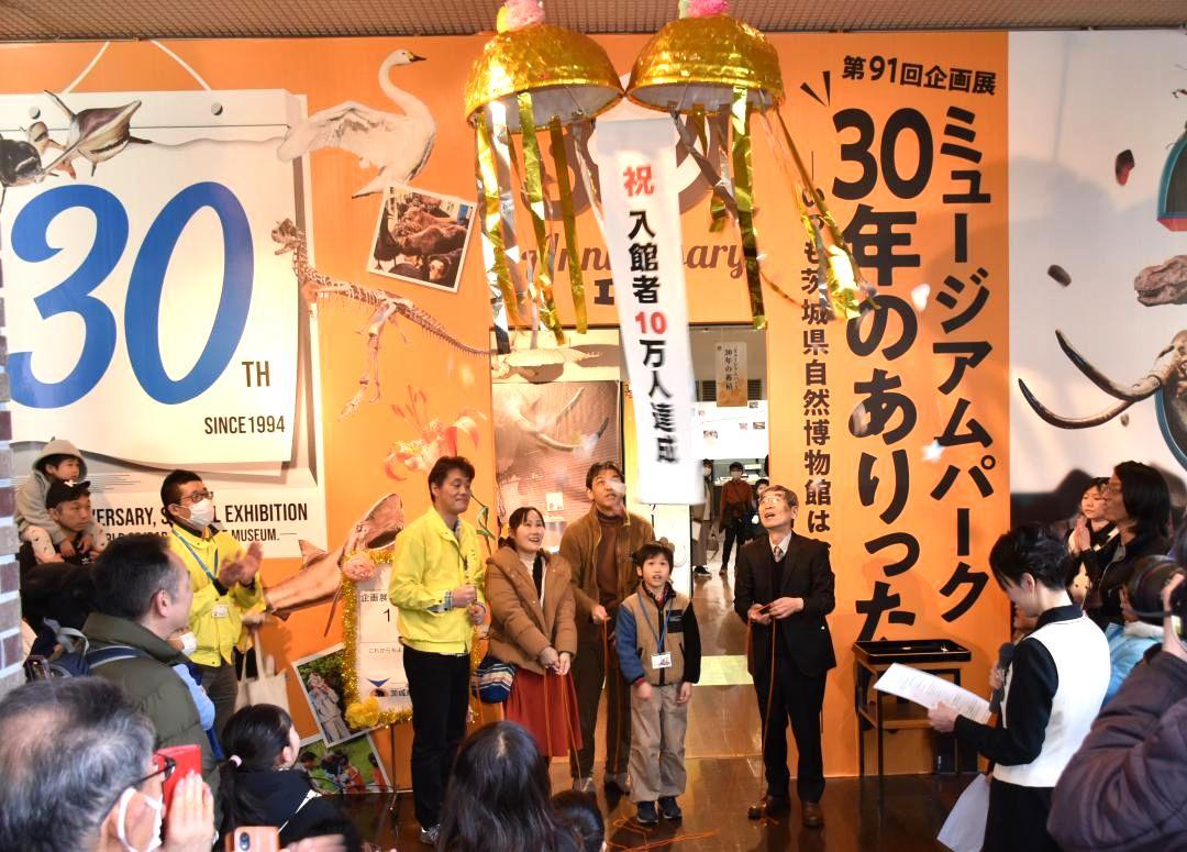 第91回企画展の入館者が10万人を達成し、くす玉をわって祝う関係者ら=坂東市大崎の県自然博物館
