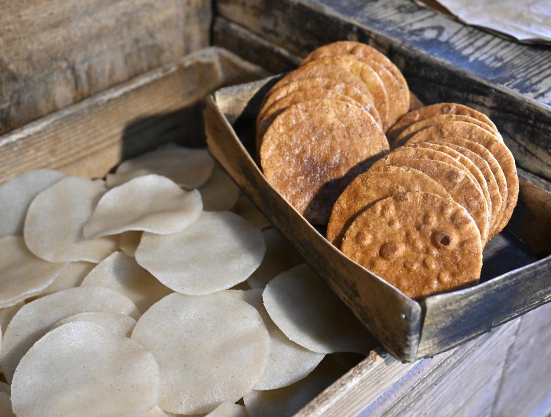 生地(左)を焼き上げ、しょうゆを塗った「あとひきせんべい」
