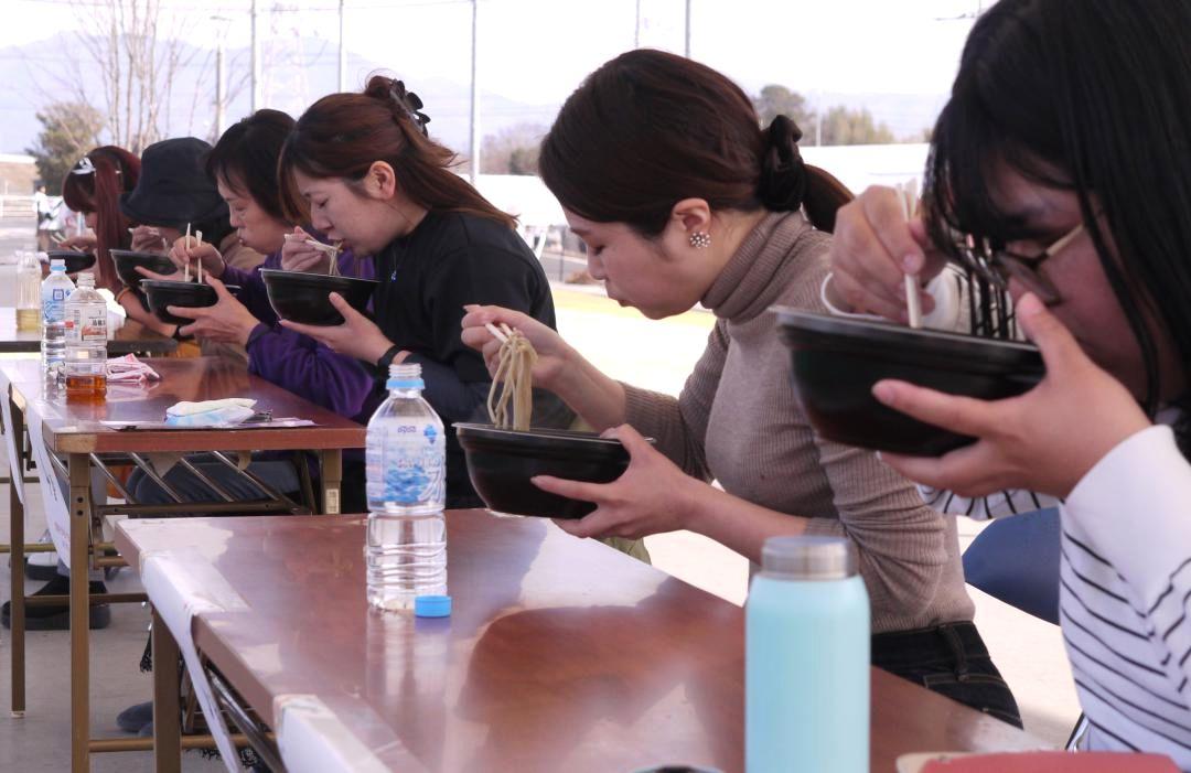 女性の部の決勝でけんちんそばをかき込む参加者=筑西市川澄
