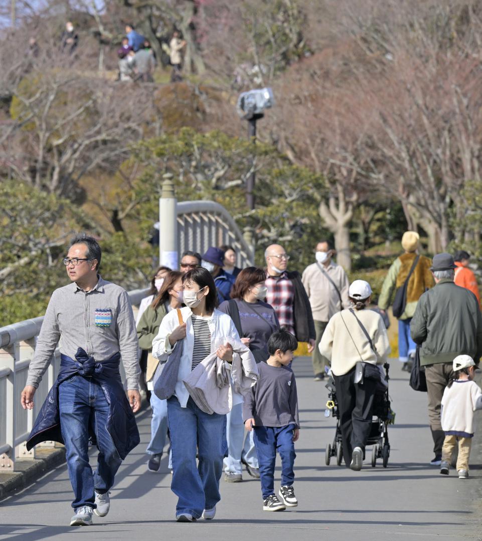 気温が上昇する中、軽装で歩く人たち=水戸市千波町
