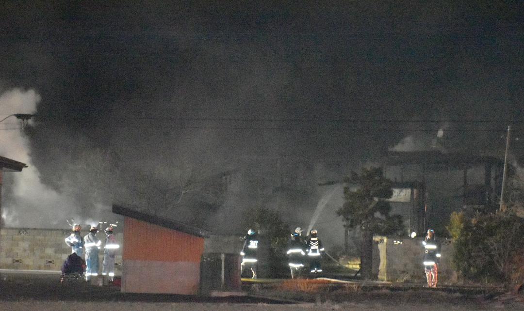 建物火災の現場で消火活動にあたる消防隊員ら=26日午後7時10分ごろ、つくばみらい市青古新田