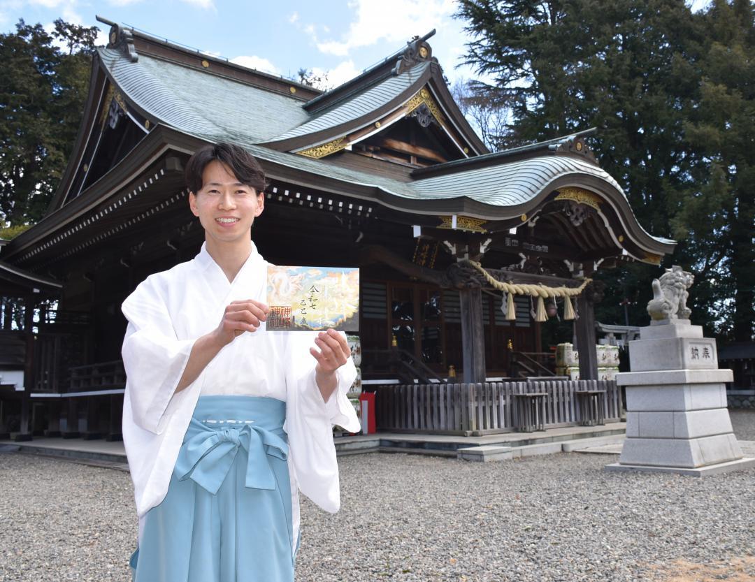 御朱印を手に神峰神社について説明する大都円権禰宜=日立市宮田町
