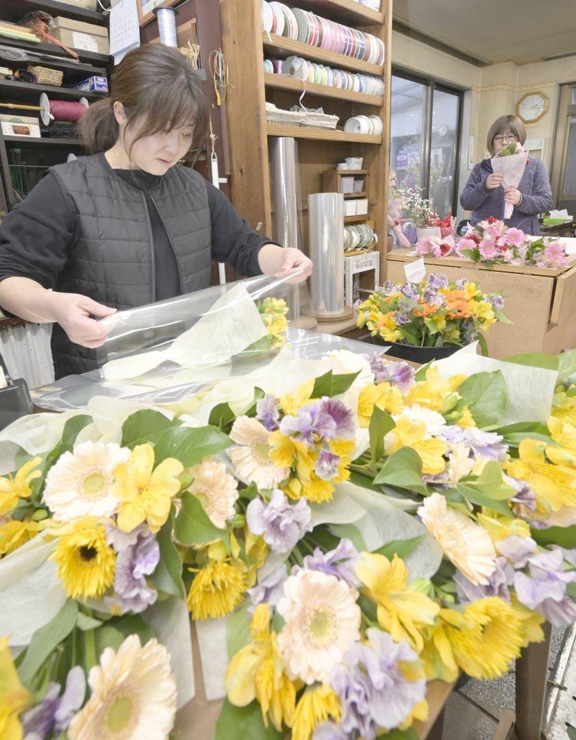 卒業式用の花束作りに追われる従業員=水戸市梅香
