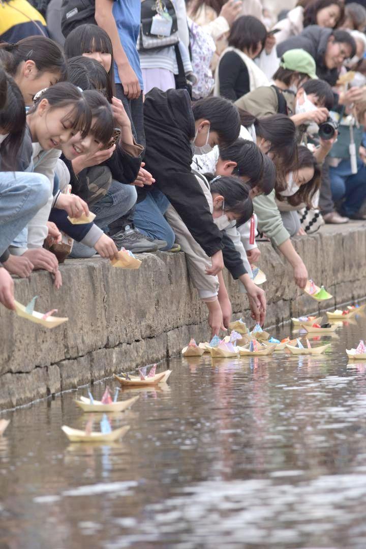 折りびなを川に流す参加者ら=桜川市真壁町飯塚
