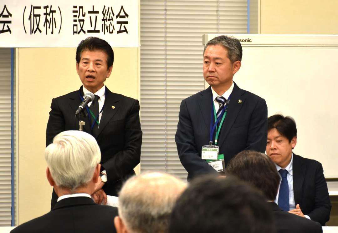 設立総会であいさつをする星野学元会長(左)と鈴木周也市長=東京都内
