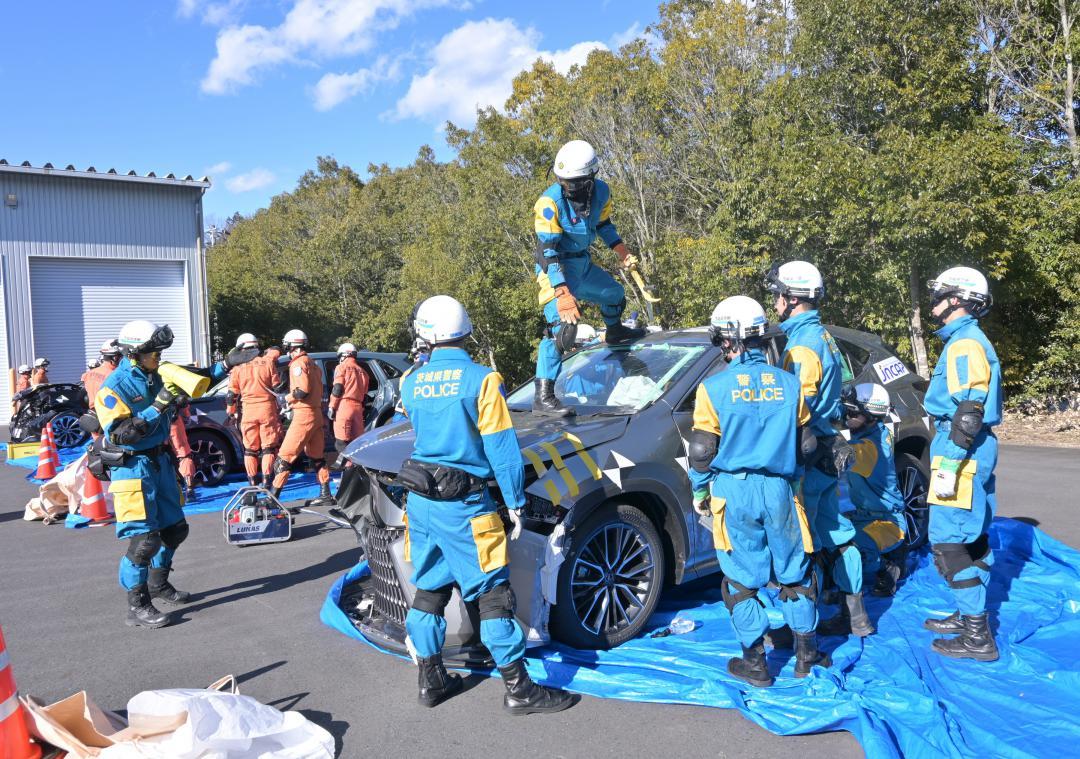 変形した乗用車の解体訓練をする県警機動隊と消防隊員ら=城里町小坂
