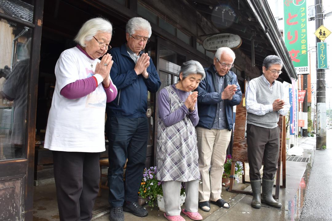 竜巻が通過した方角に手を合わせる住民=つくば市北条