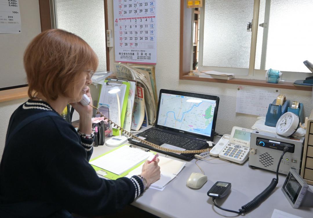 500円タクシーの配車予約に応じるひまわり交通のスタッフ=大洗町五反田
