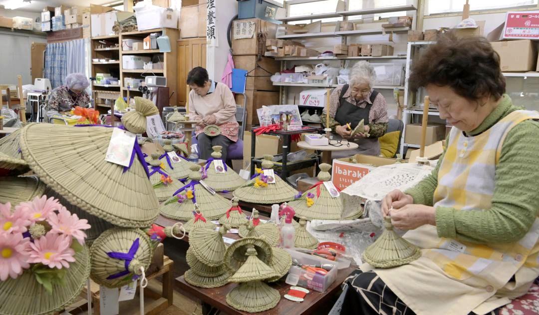 一つ一つ丁寧に「あやめ笠」を作る会員ら=潮来市辻
