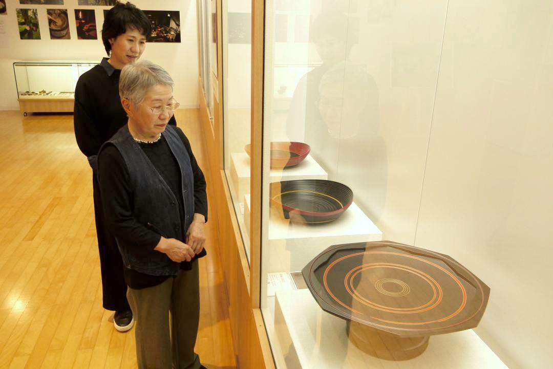 大西勲さんの作品「曲輪造八角足付盛器」(手前)などを眺める大西さんの妻かをるさん(同)と長女の未穂さん=筑西市大塚
