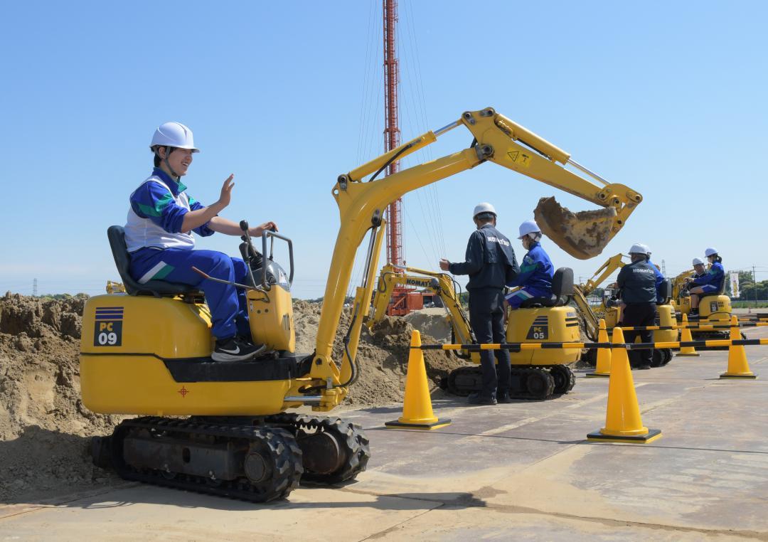 ショベルカーの操縦を体験する生徒たち=稲敷市甘田
