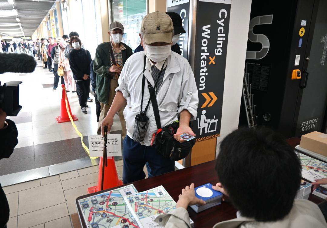 マンホールカードの配布で行列して並ぶアニメファン=4月25日、JR土浦駅