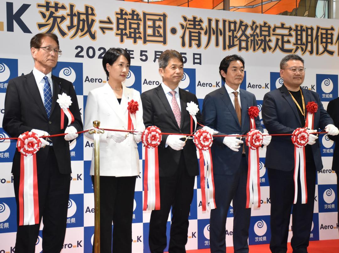 定期便化を祝いテープカットする大井川和彦知事(中央)とエアロKの姜秉浩CEO(右から2人目)ら=小美玉市与沢