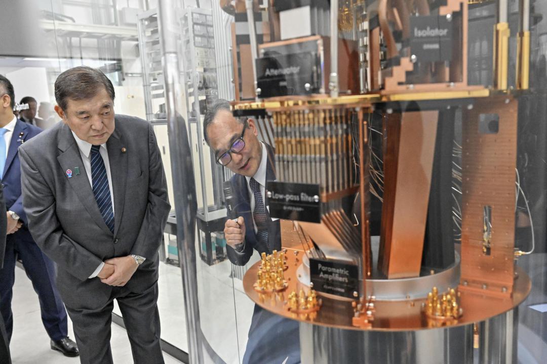 超電導型量子コンピューターの内部模型を前に説明を受ける石破首相(左)=18日午後、つくば市梅園(代表撮影)
