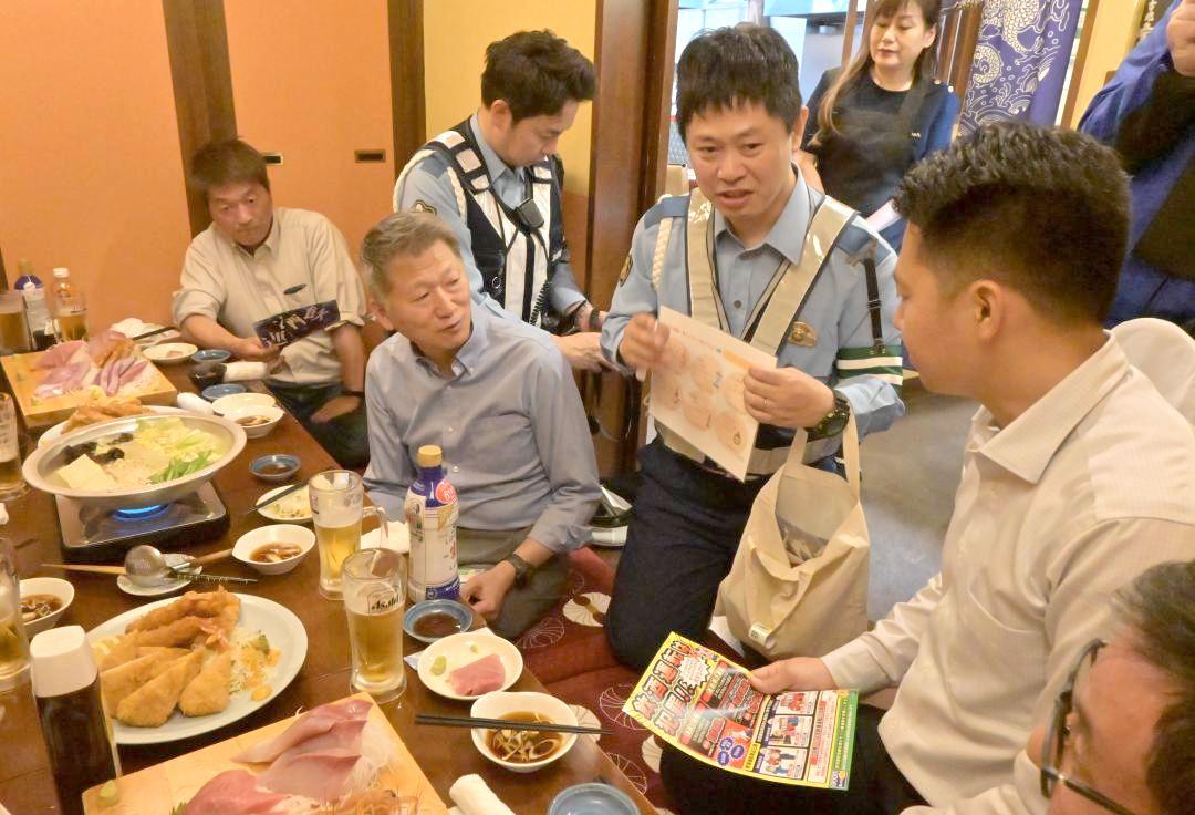 居酒屋利用客に飲酒運転の根絶を呼びかける警察官=16日、土浦市桜町
