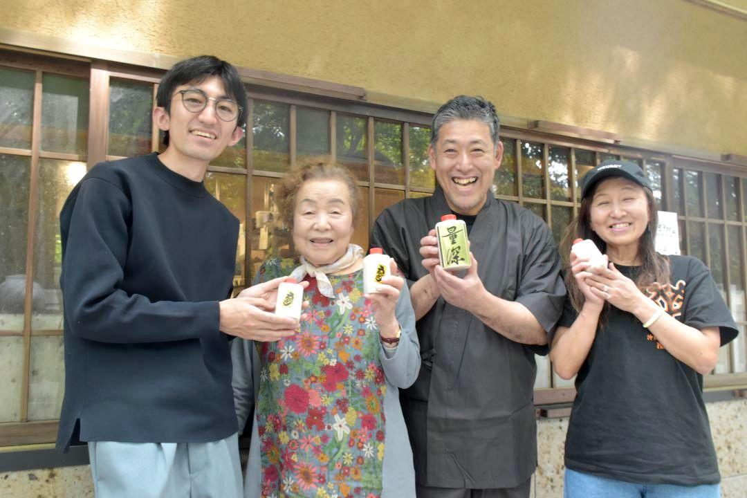 来店者にコメを手渡した馬場万作さん(右から2人目)=笠間市笠間