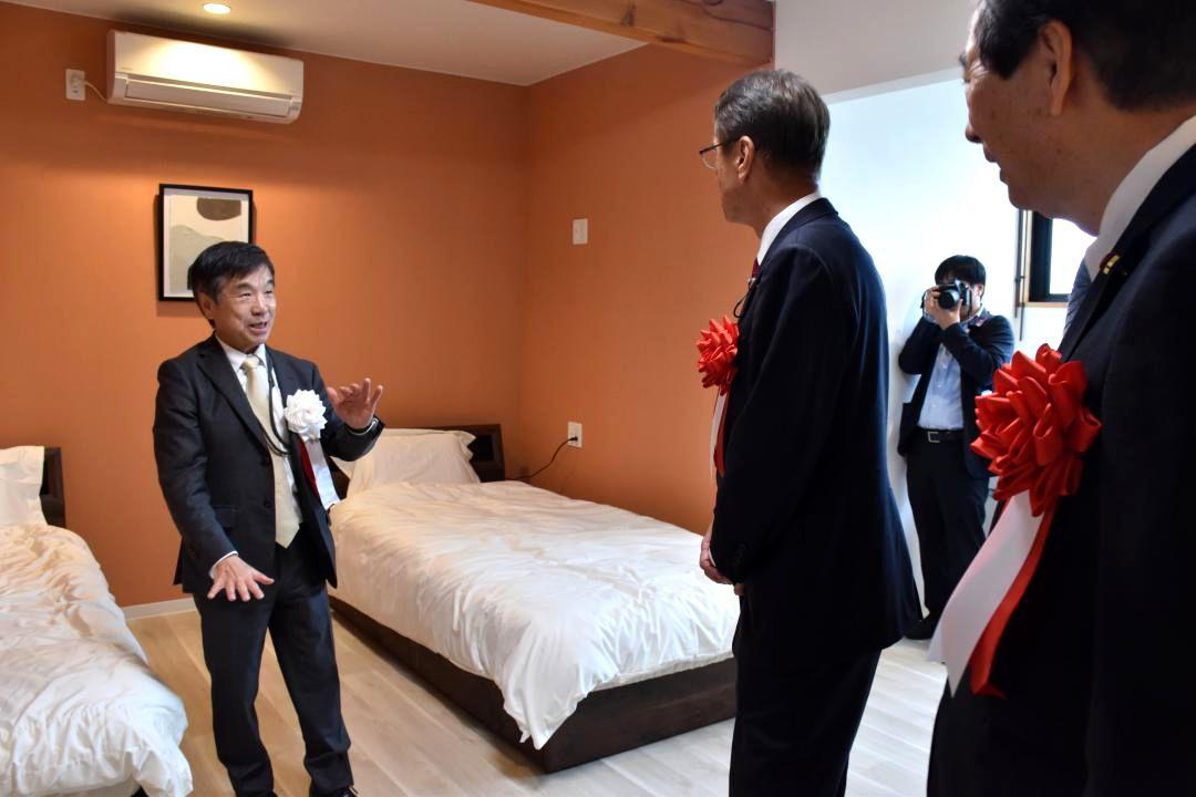 来賓に施設の説明をする高野賢社長(左)=常陸大宮市野口