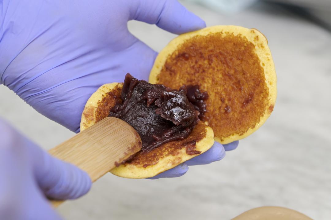 自家製の粒あんを、どら焼きの皮に詰める作業