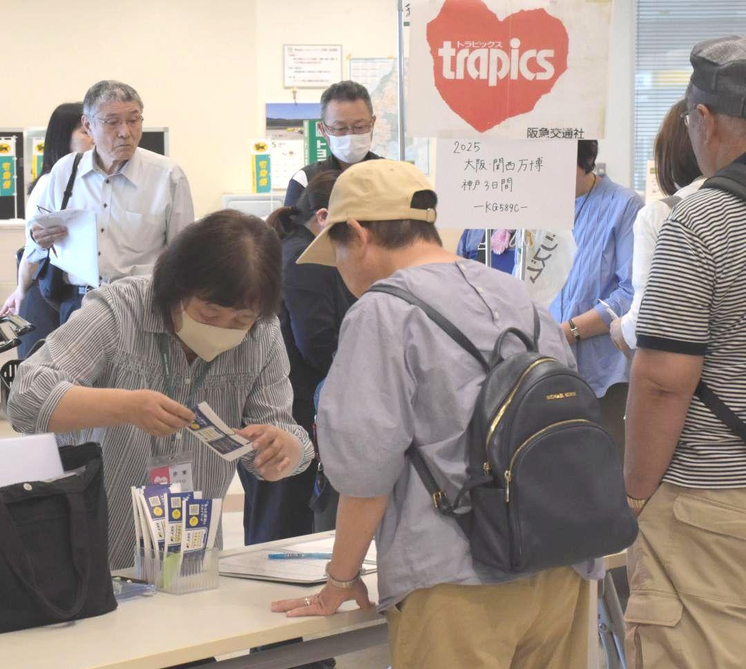 阪急交通社の万博ツアーで利用客に航空券を渡す係員=小美玉市与沢の茨城空港