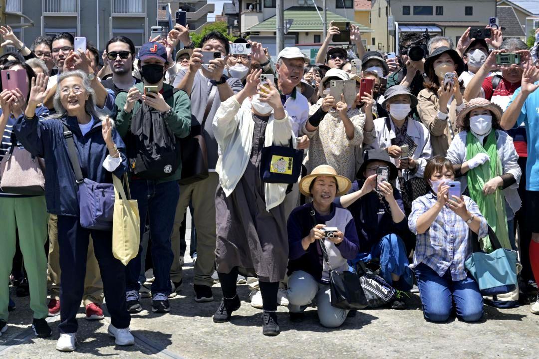 横綱大の里が姿を見せ、手を振ったり写真に収めたりする、部屋の前に集まった相撲ファン=28日午前、阿見町荒川本郷