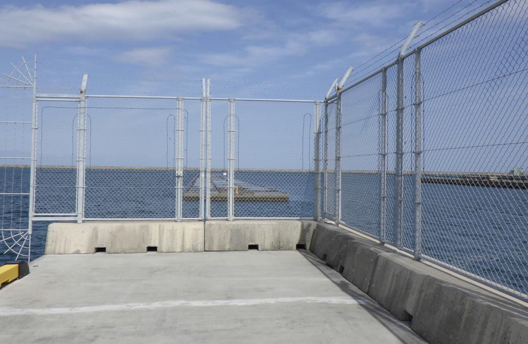 新たな国際物流ターミナルの本格整備が始まる常陸那珂港区中央埠頭のDバース。フェンスの先にEバースが整備される=ひたちなか市(国土交通省提供)